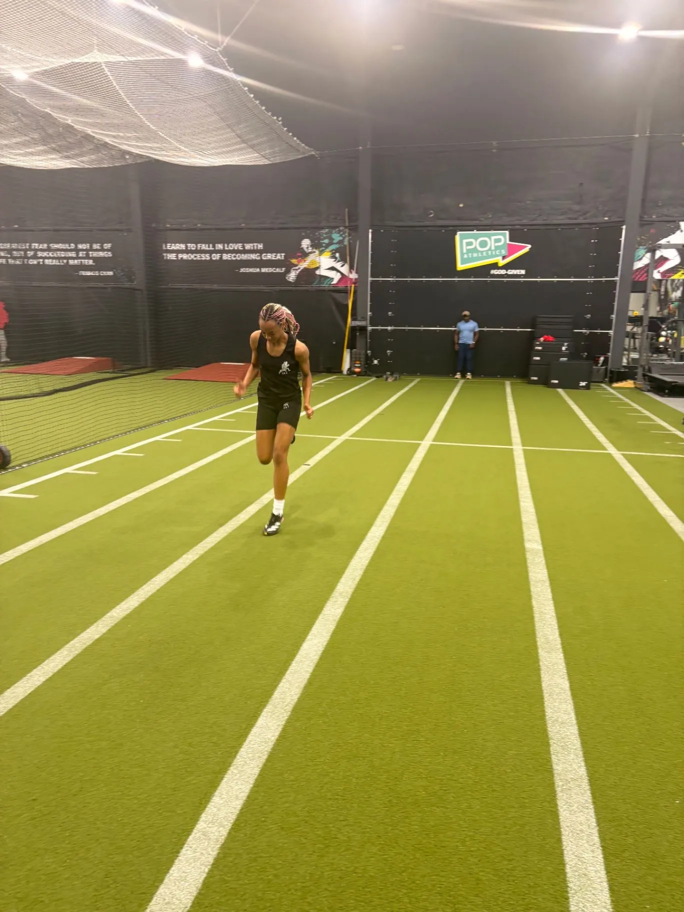 Nailah Belcher sprinting down an indoor training lane
